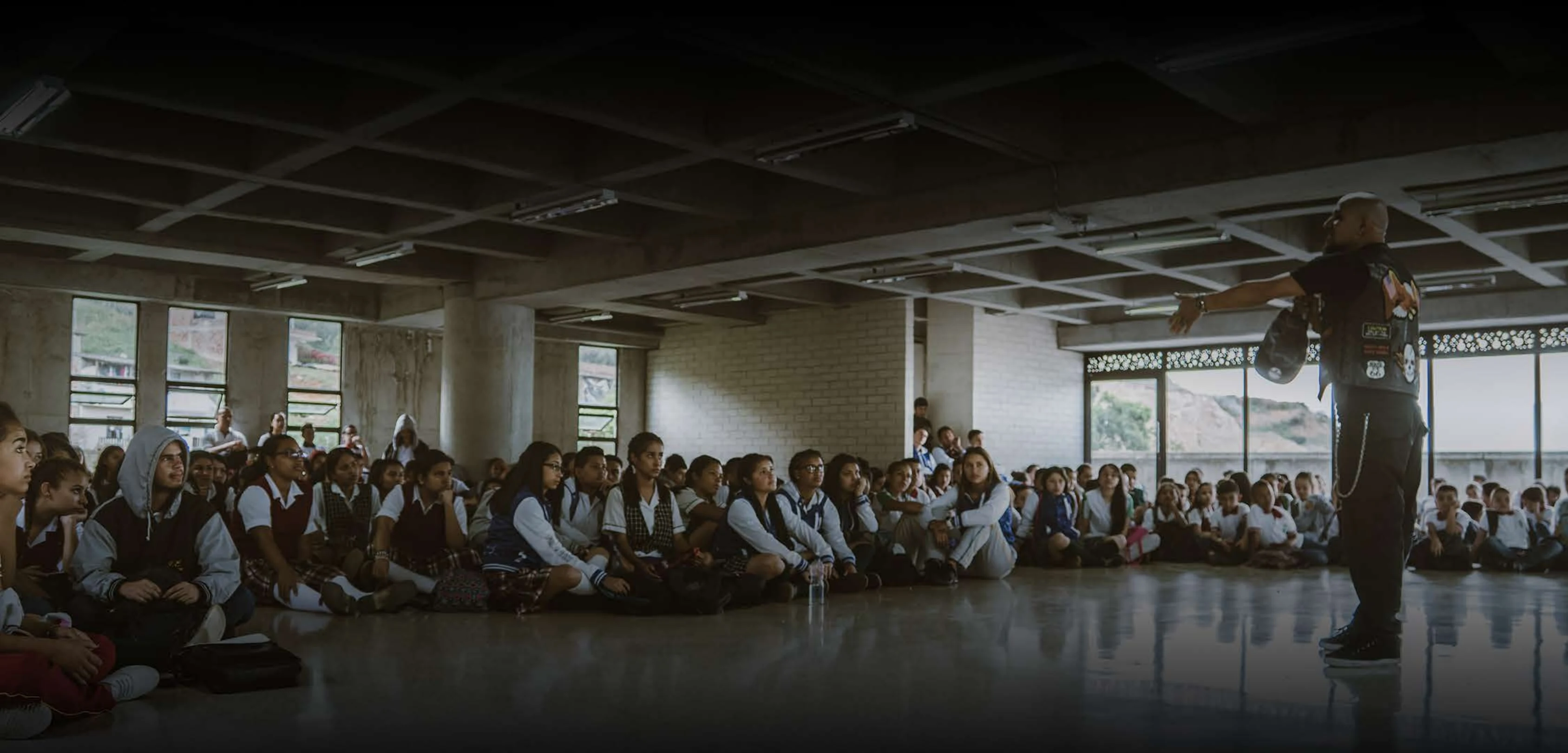 Un integrante de Breska conversa con estudiantes durante un encuentro escolar